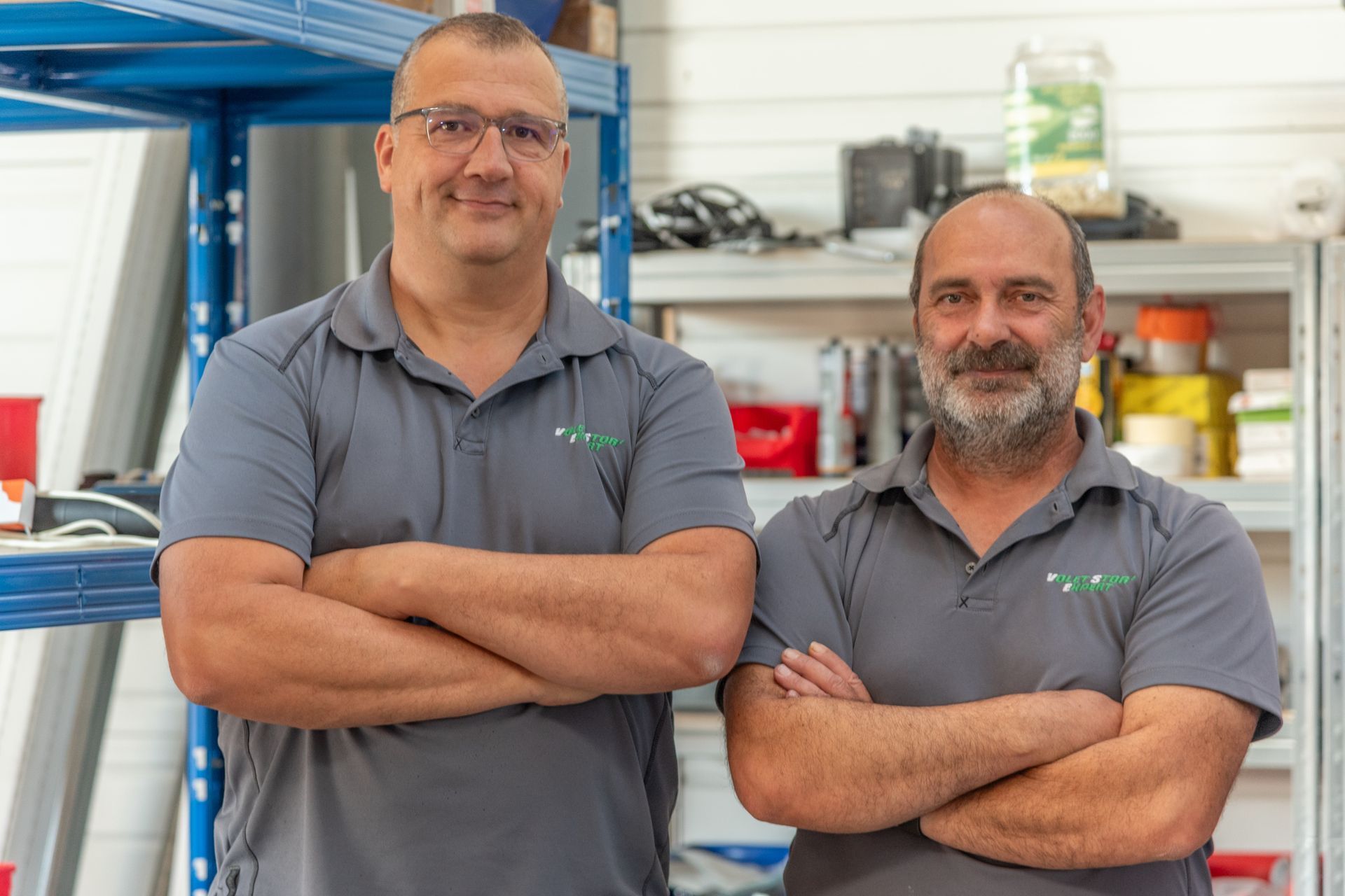 Deux hommes dans un décor d'atelier.