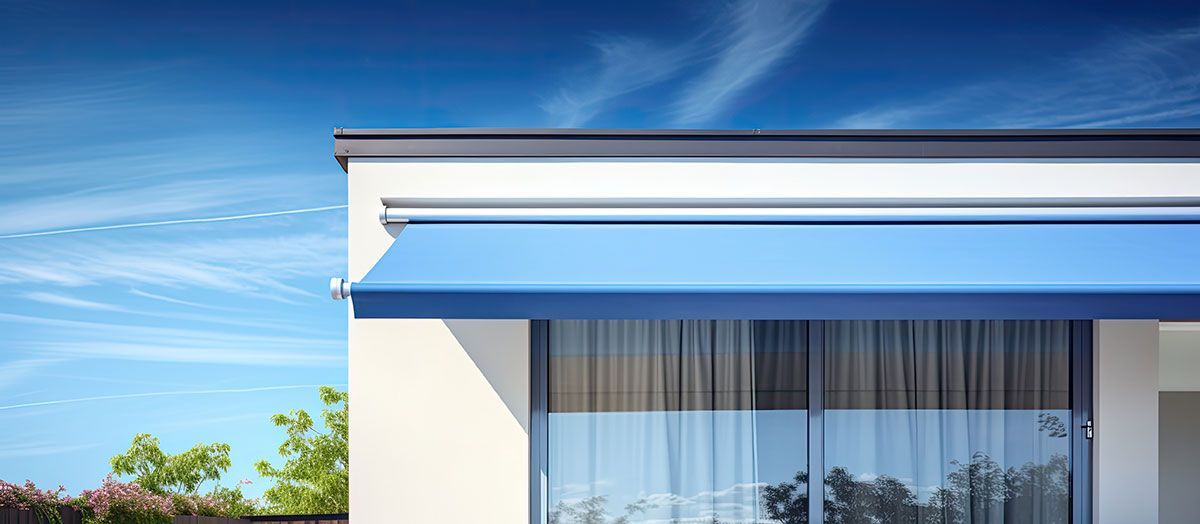 Zoom sur une façade de maison avec un store banne bleu et une baie vitrée