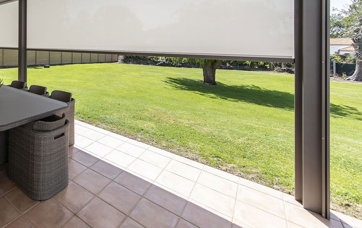 Jardin avec une véranda munie de stores verticaux