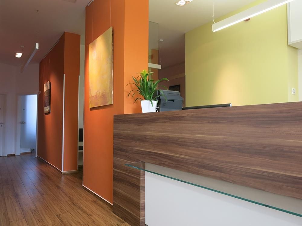 Eine Holztheke in einem Flur mit orangefarbenen Wänden