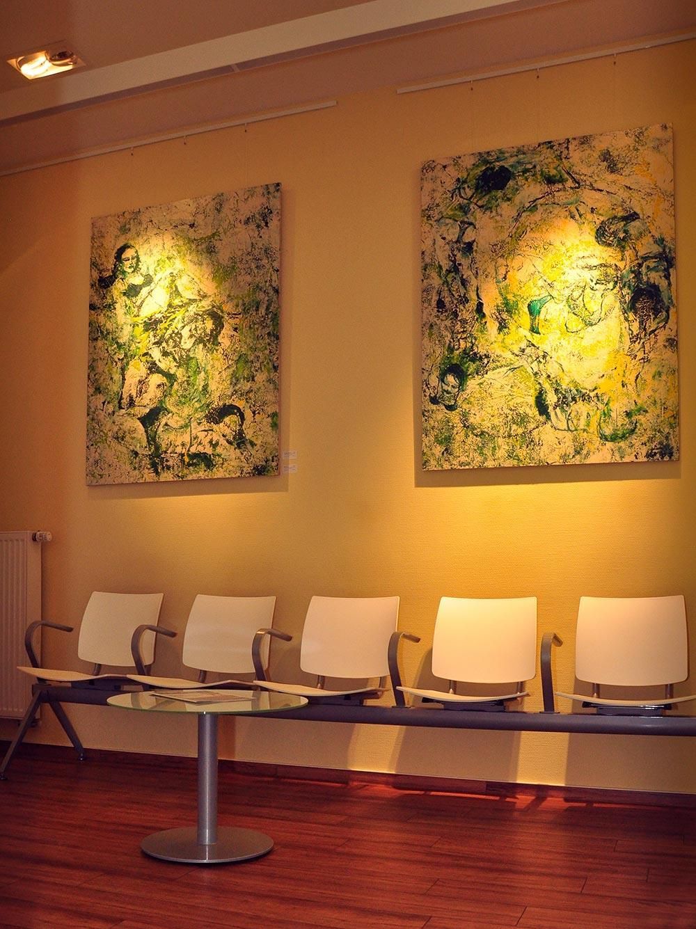 Ein Wartezimmer mit Stühlen und Gemälden an der Wand
