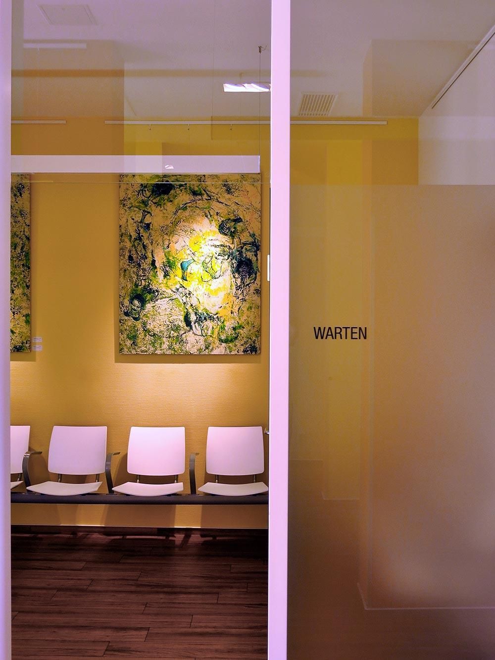 Ein Wartezimmer mit Stühlen und einem Gemälde an der Wand