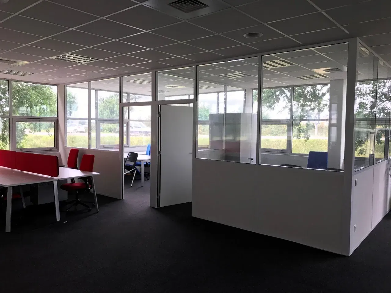 Intérieur d'un bureau avec un box privée aux grandes vitres
