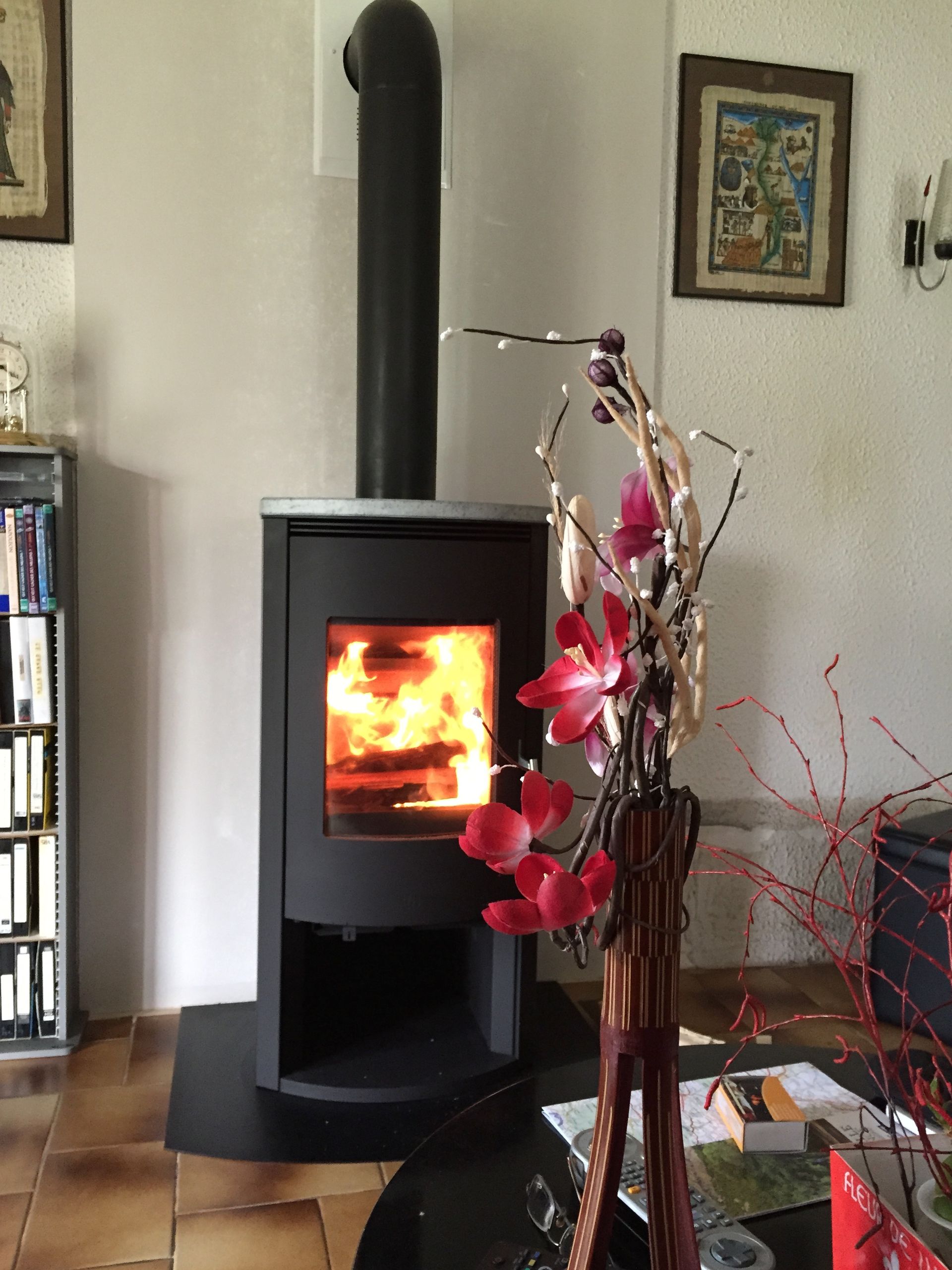 Mise en situation d'un poêle à bois dans un salon avec conduit dans le mur.
