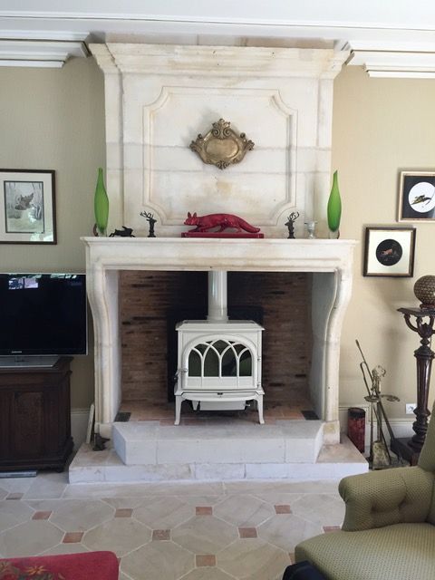 Un poêle à bois mis dans une ancienne cheminée en pierre.