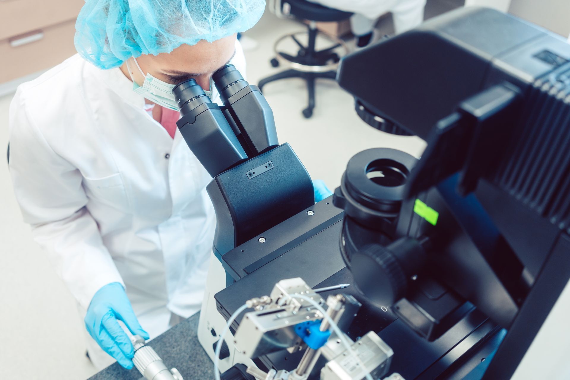 Ein Wissenschaftler schaut in einem Labor durch ein Mikroskop.