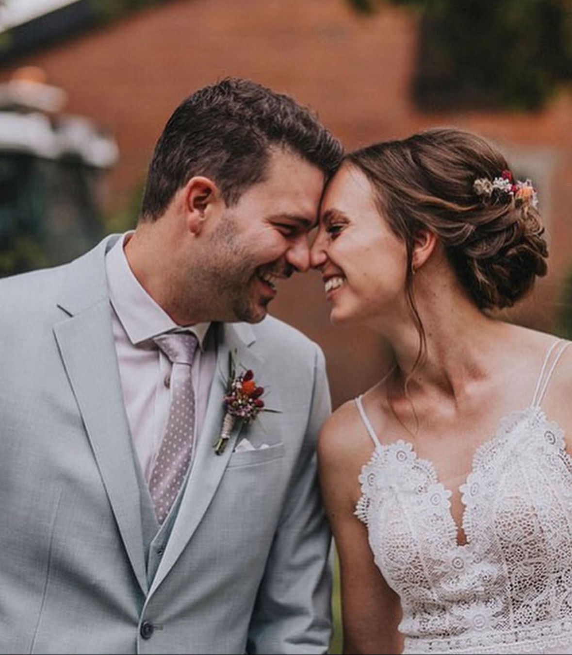 Verliebtes Brautpaar, seitlich fotografiert, Braut mit schönem Gesteck