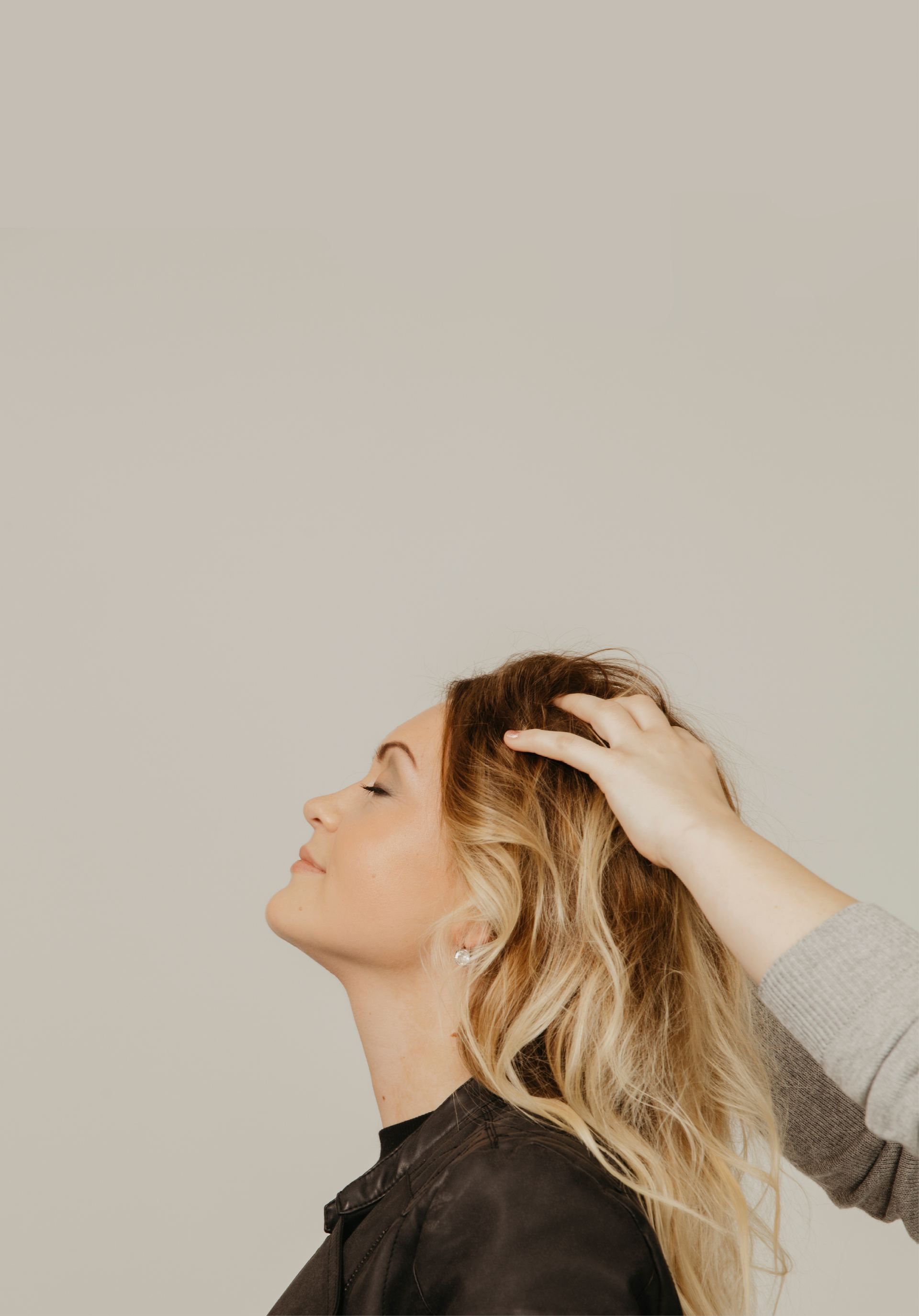 Kopfmassage bei einer Frau mit blondierten Haaren