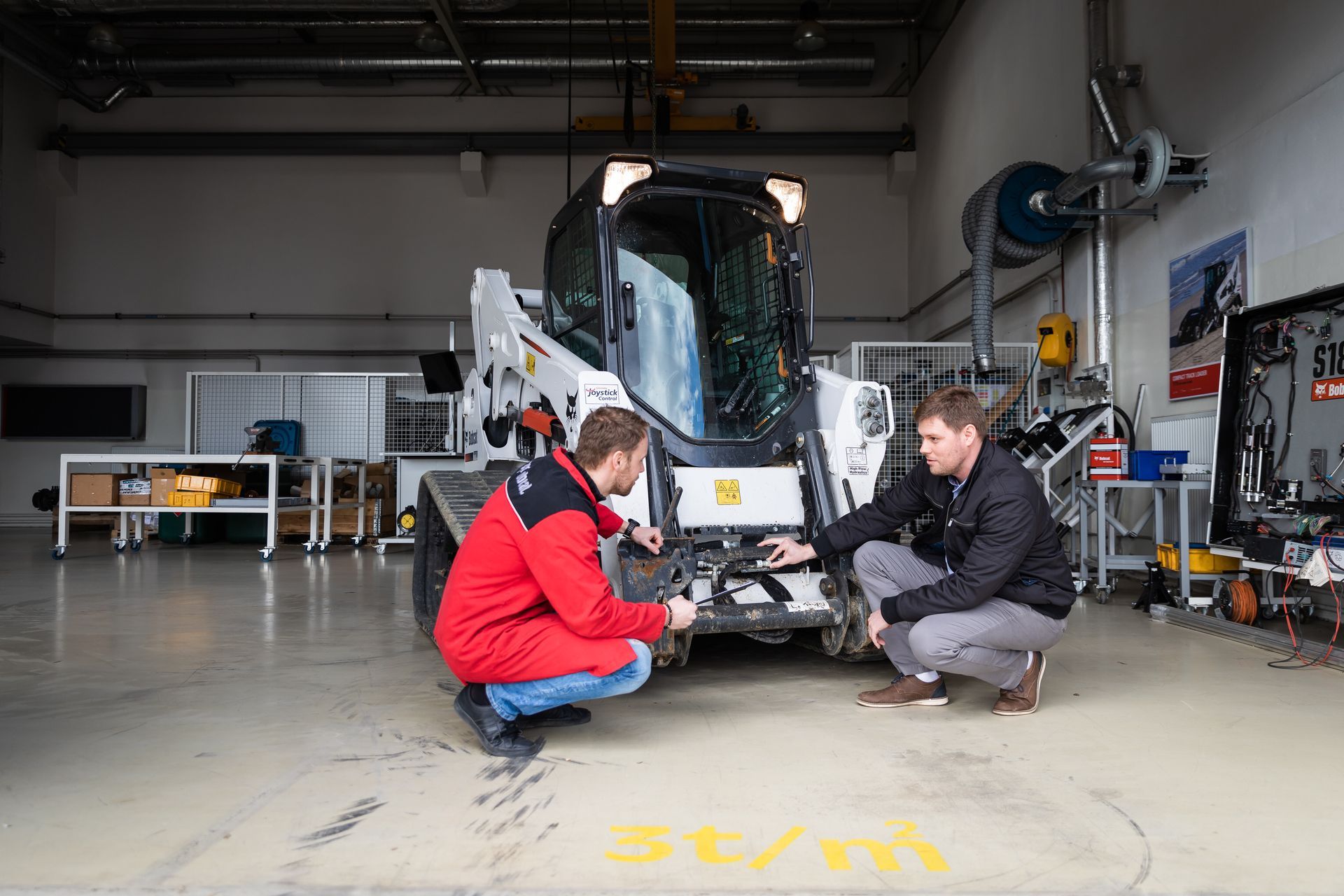 Gros plan sur un ouvrier qui tient une tablette devant un camion