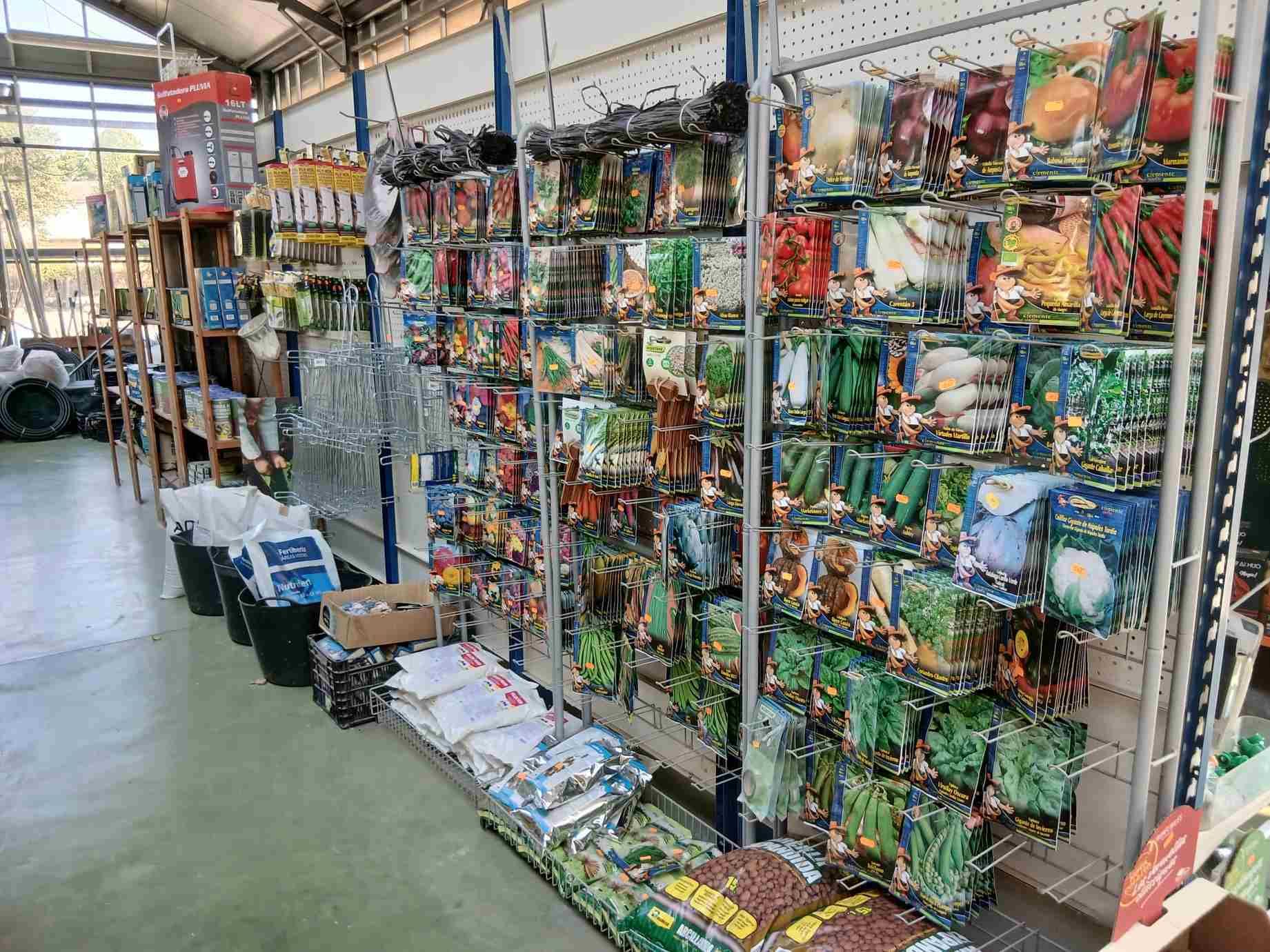 Dentro de una tienda de jardinería, paquetes de semillas exhibidos en los estantes.