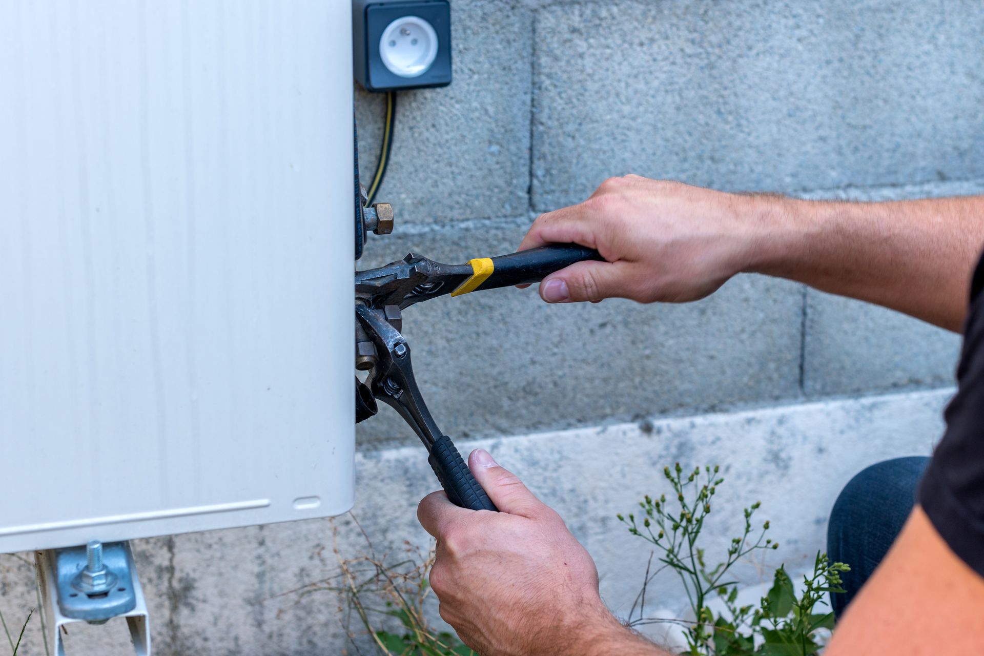 Focus sur un homme qui vis un écrou à la pince