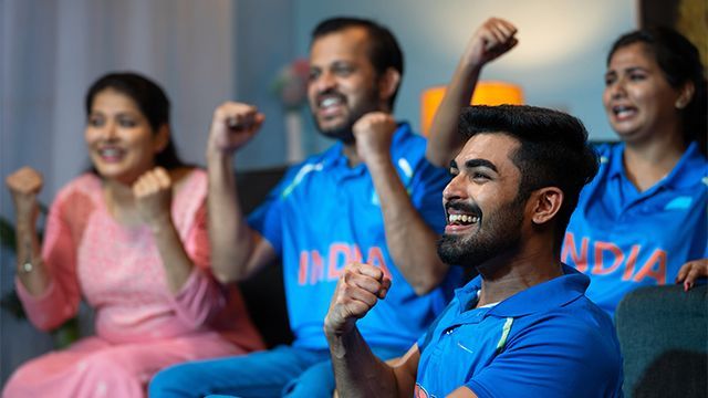 Famille indienne supportant son équipe de cricket favoris grâce à l'installation d'une parabole