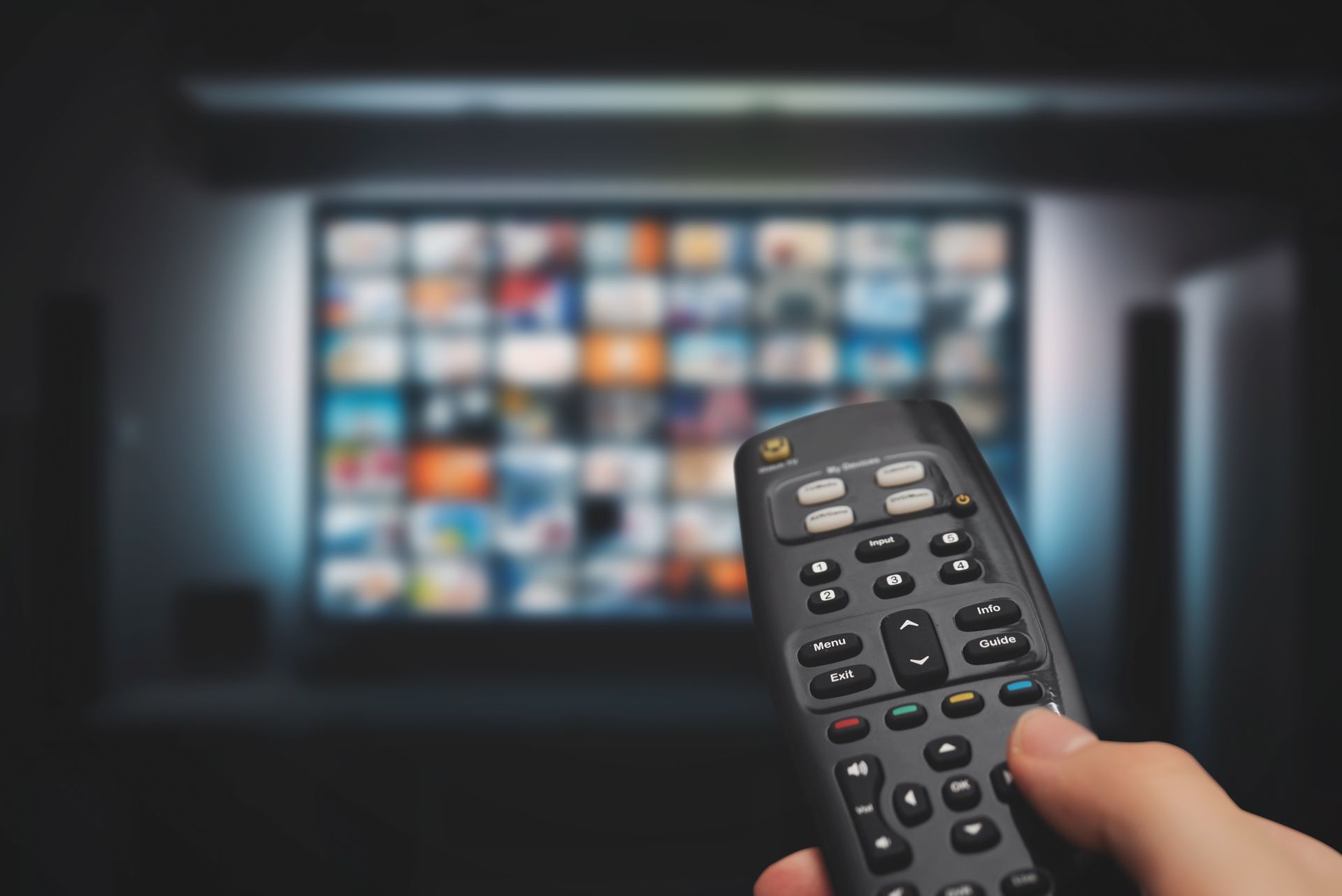 Gros plan sur une télécommande avec une télévision en fond