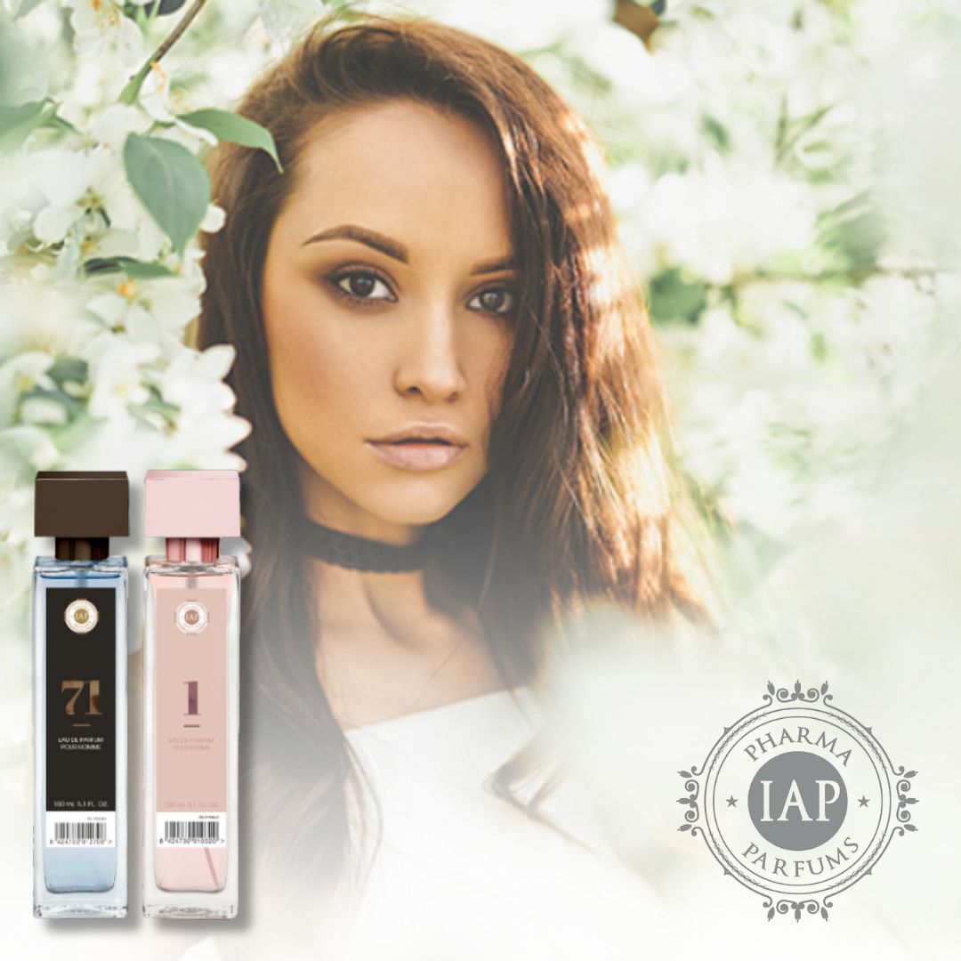 Primo piano di giovane donna con capelli lunghi rossi e mossi, circondata da fiori. Sul lato destro due flaconi di profumo e su quello sinistro il logo di IAP Parfum
