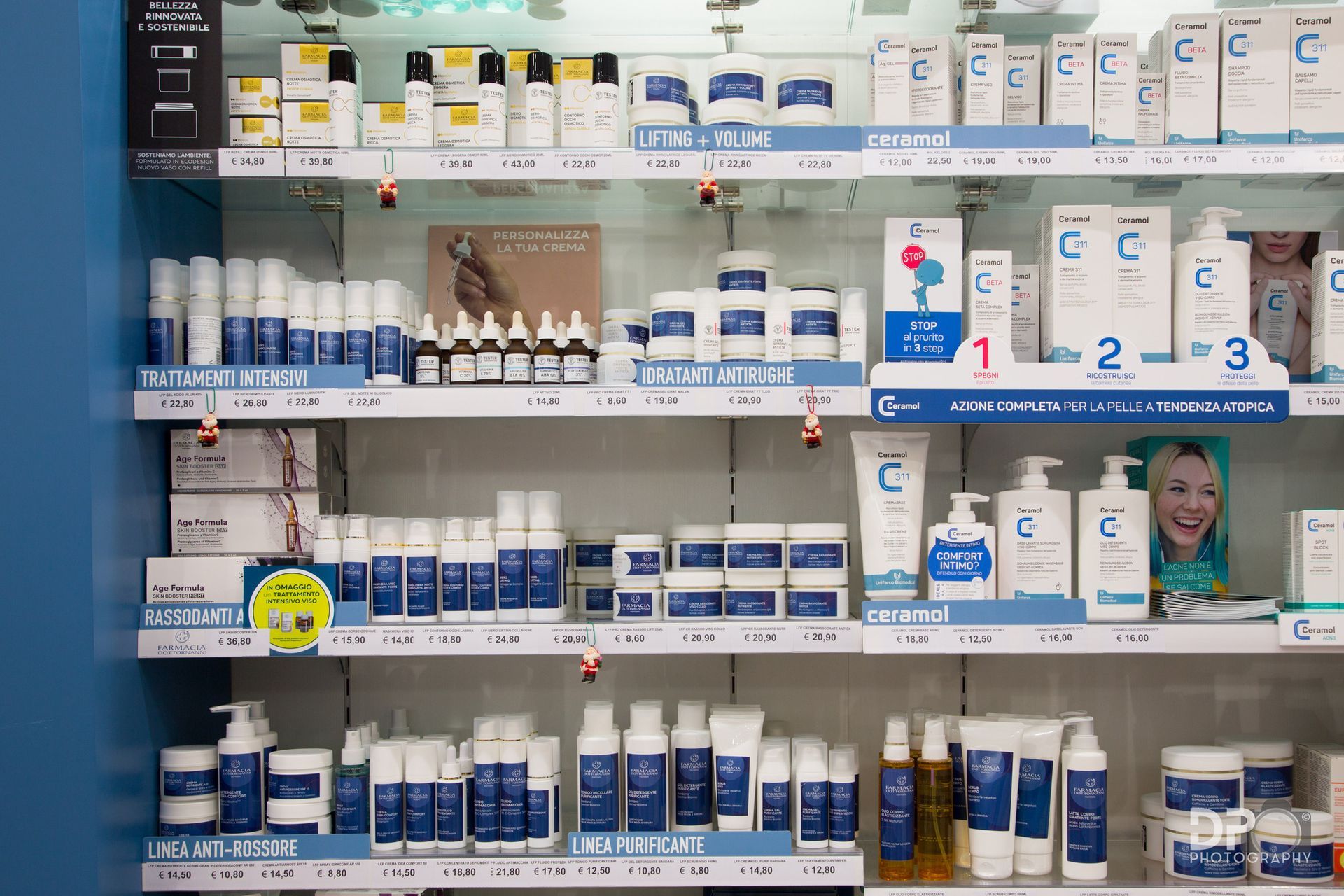 Uno scaffale di farmacia ben illuminato, pieno di file di prodotti e lozioni per la cura della pelle blu e bianchi.