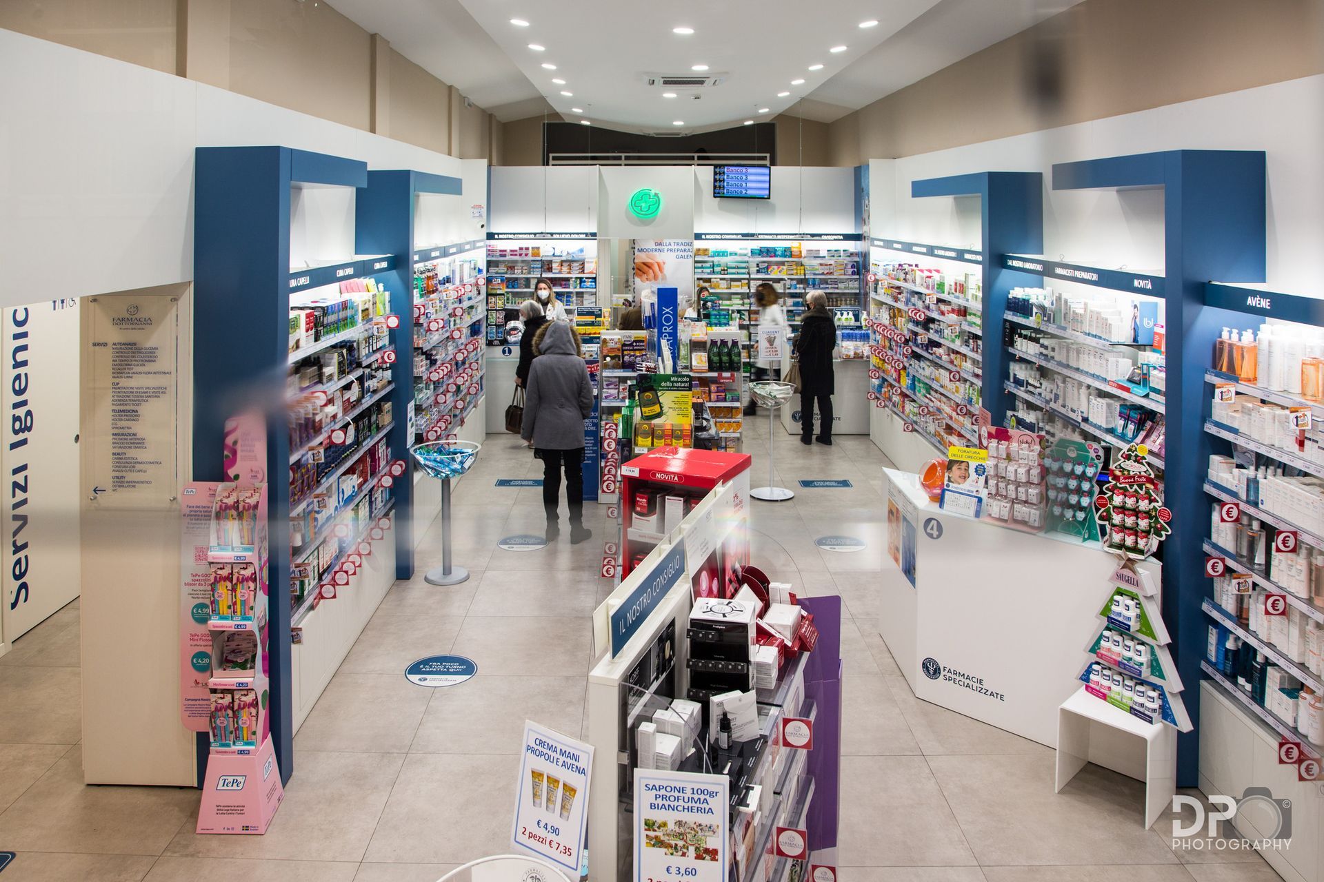 Farmacista in camice bianco, con in mano un blocco per appunti, ispeziona gli scaffali di una farmacia.