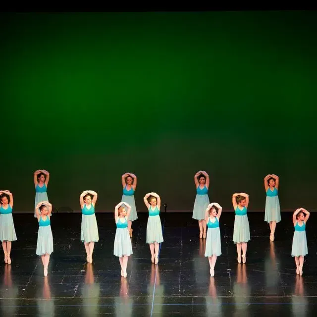 Un grup de noies joves ballen en un escenari.