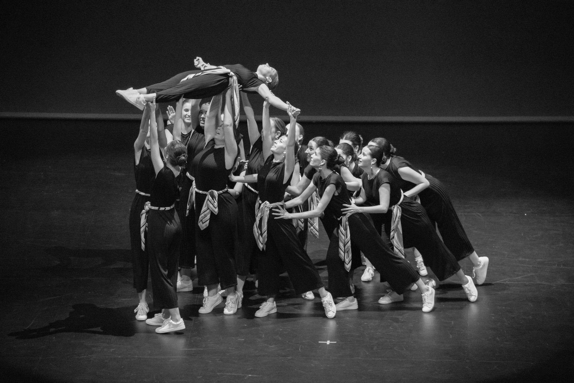 Una fotografía en blanco y negro de un grupo de bailarines en un escenario.