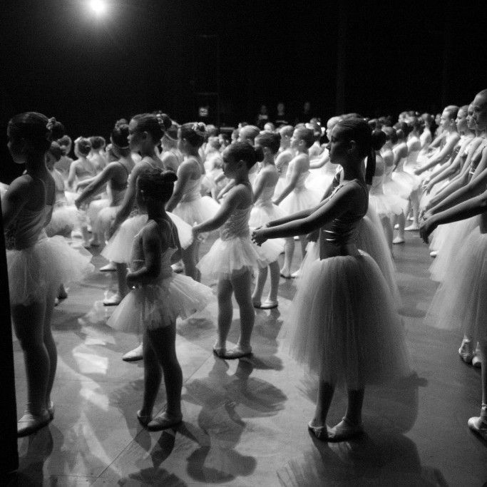 Un grupo de mujeres está sentada en un escenario frente a un fondo azul.