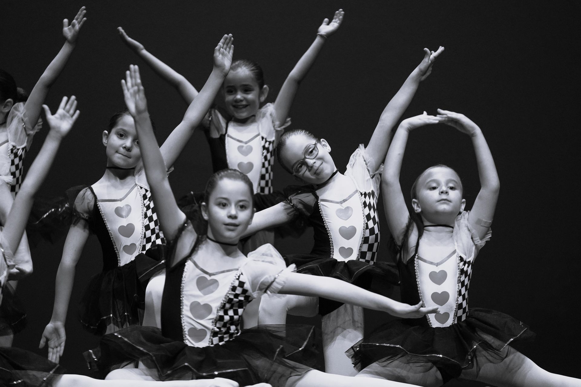 Un grupo de chicas jóvenes bailan en una fotografía en blanco y negro.