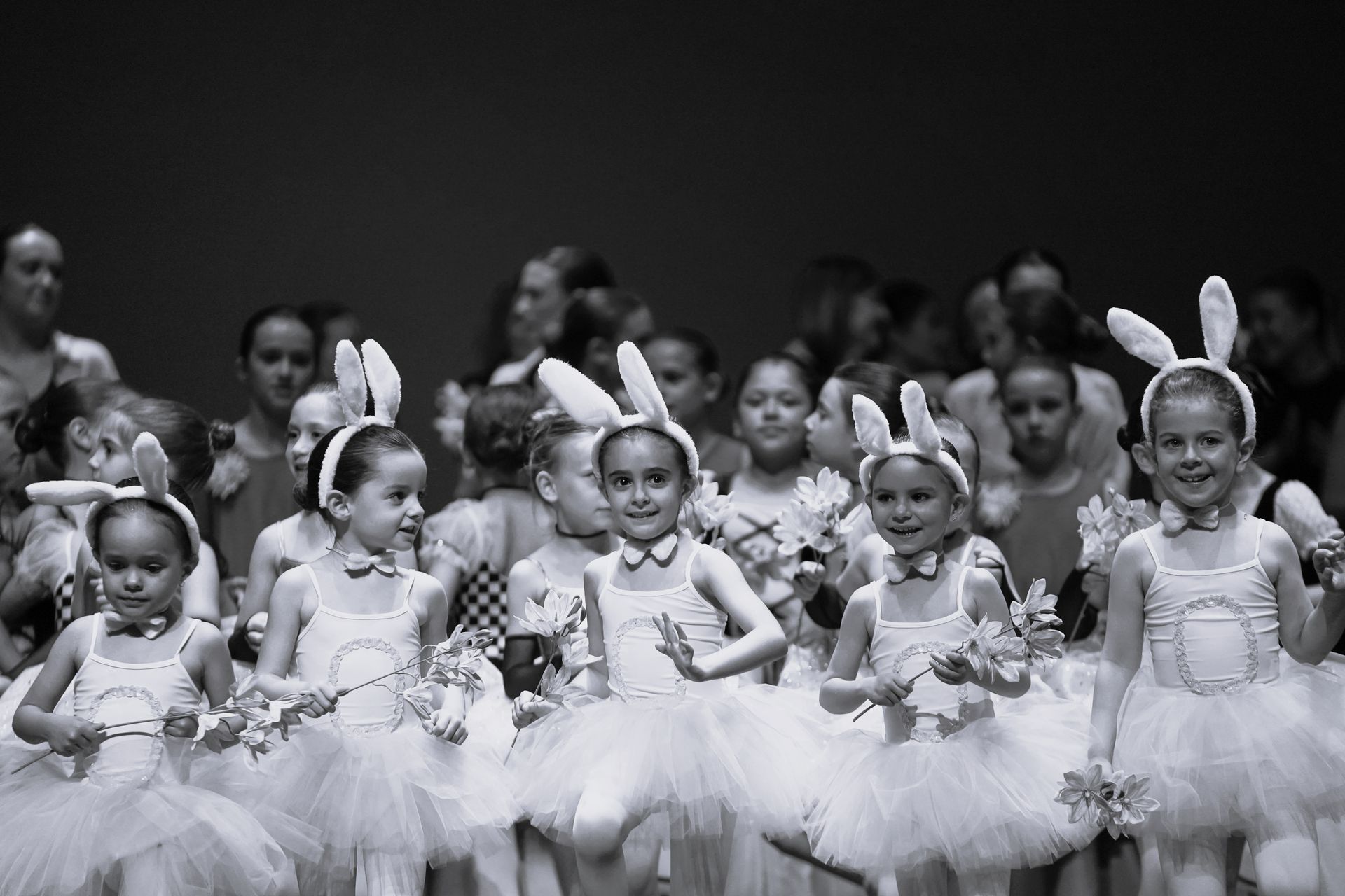 Una fotografía en blanco y negro de un grupo de niñas con tutús y orejas de conejo.