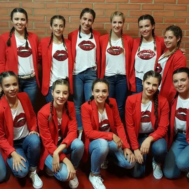 Un grup de noies amb jaquetes vermelles i camises blanques amb llavis