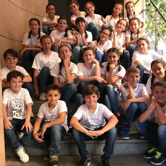 Un grup de nens posa per a una foto i un d'ells porta una samarreta que diu 