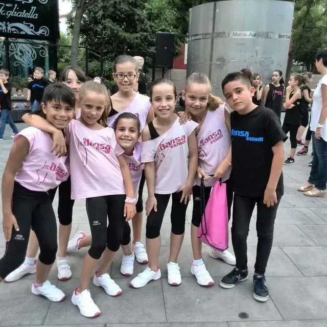 Un grup de noies joves posen per a una foto amb una noia que porta una samarreta que diu 