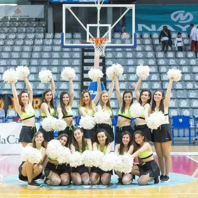 Un grup d'animadores sostenint pompons en una pista de bàsquet
