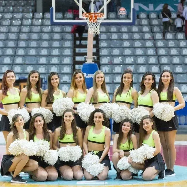 Un grup d'animadores posant per a una foto en una pista de bàsquet