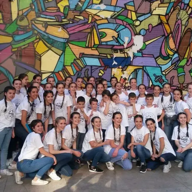 Un grup de persones posant per a una foto davant d'un mural de colors