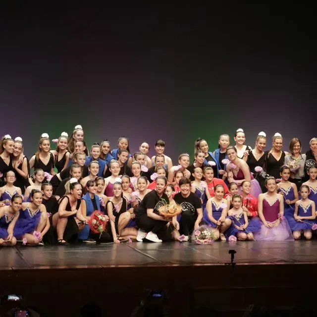 Un gran grup de persones posant per a una foto en un escenari