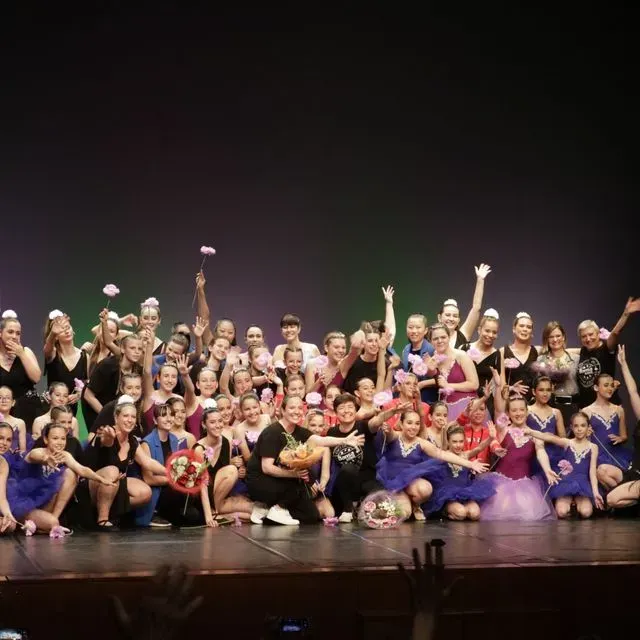 Un gran grup de persones posant per a una foto en un escenari