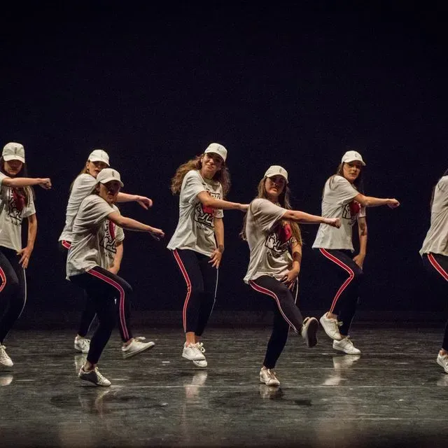 Un grupo de mujeres jóvenes están bailando en un escenario.
