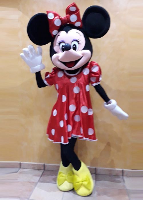 Una mascota de Minnie Mouse con un vestido de lunares rojos y blancos.