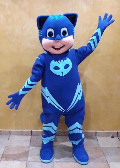 Una persona con un disfraz de PJ Masks está parada sobre un piso de baldosas.
