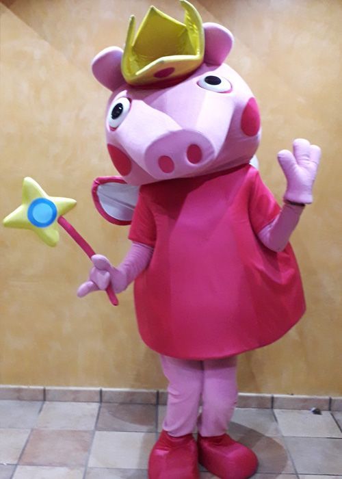Una mascota de Peppa Pig lleva una corona y sostiene una varita.