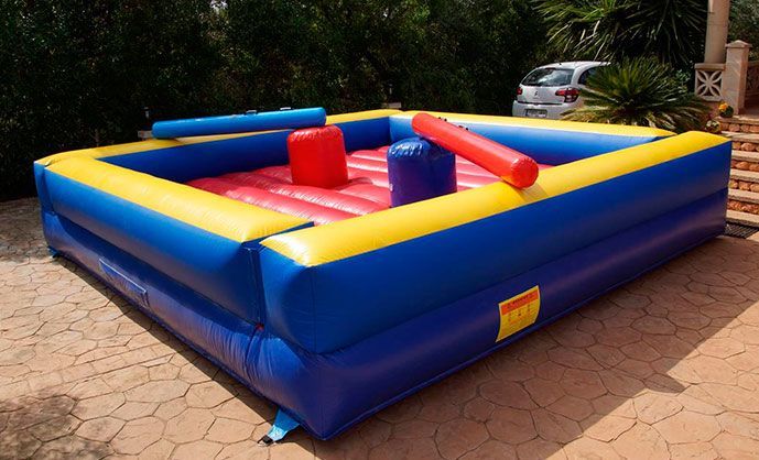 Un castillo inflable azul y amarillo con cojines rojos y amarillos.