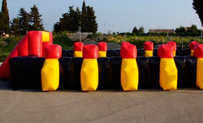 Una fila de bolos inflables rojos y amarillos