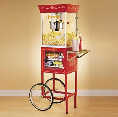 Una máquina de palomitas de maíz roja con un carrito adjunto.