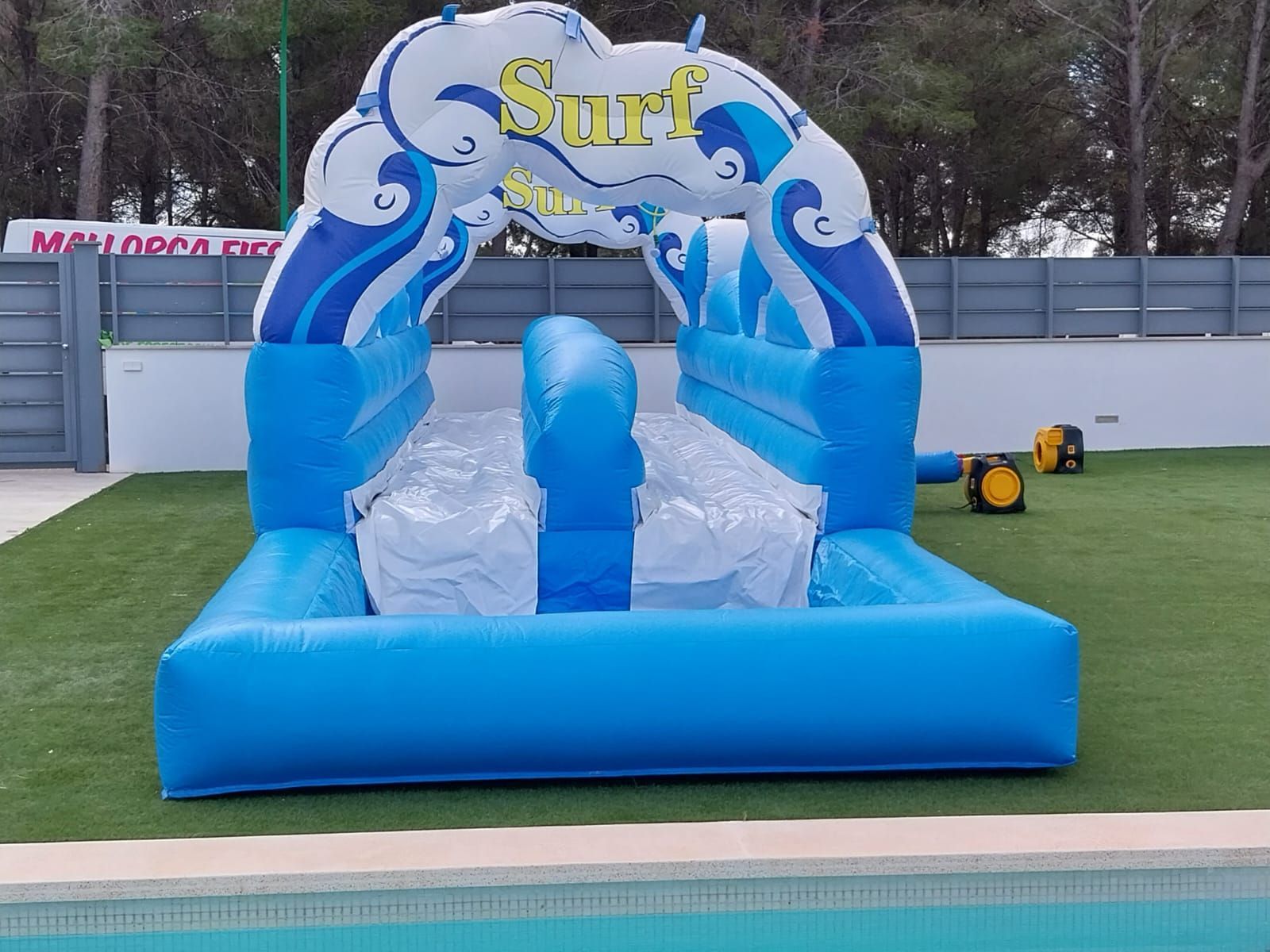 Un tobogán de agua inflable azul y blanco con la palabra surf en él.