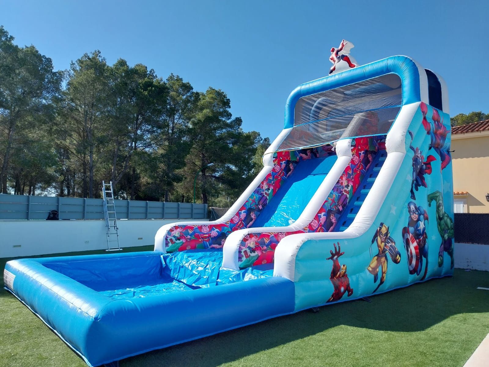 Un gran tobogán de agua inflable se encuentra sobre un exuberante campo verde.