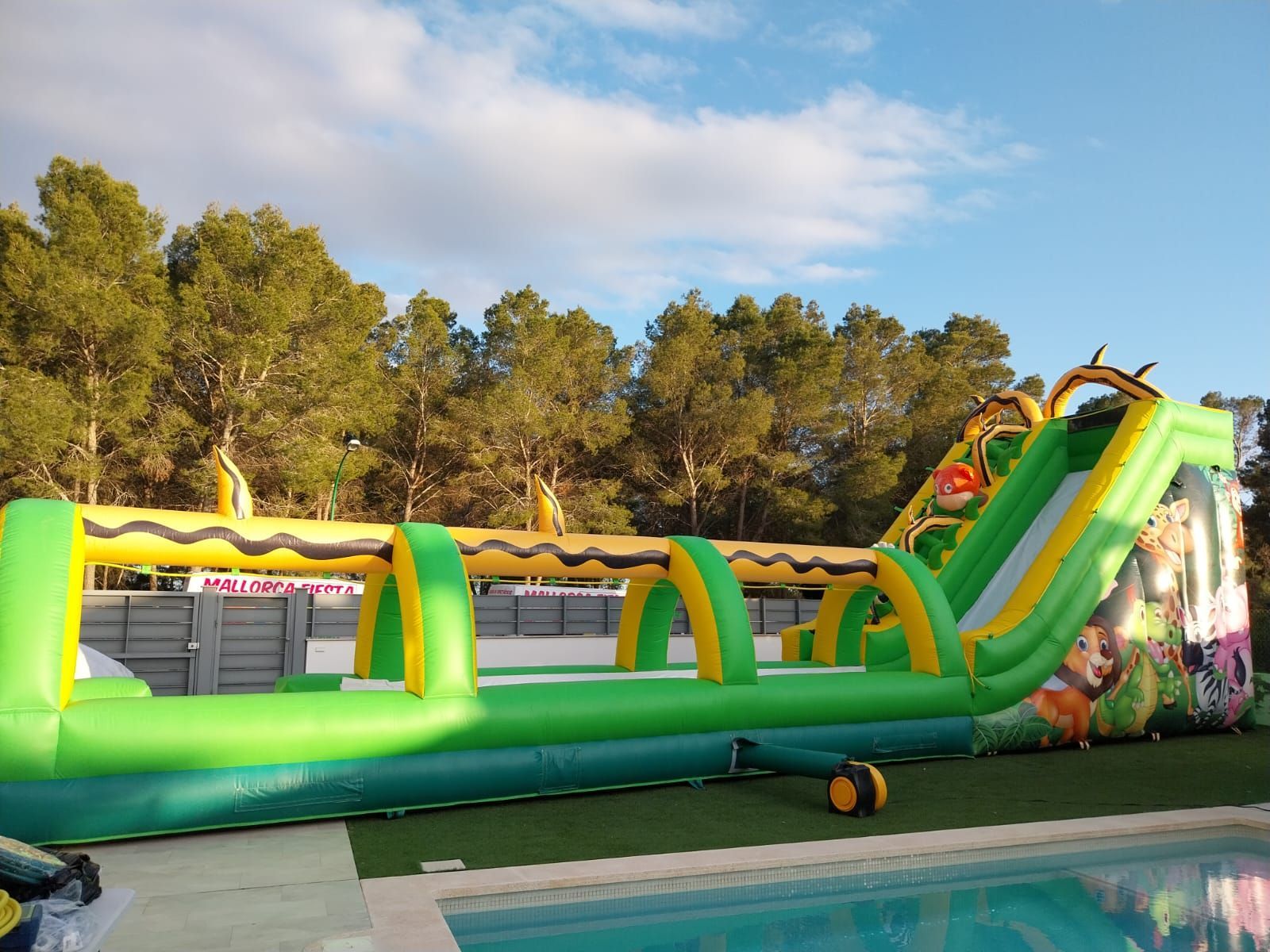 Un gran tobogán de agua inflable está al lado de una piscina.