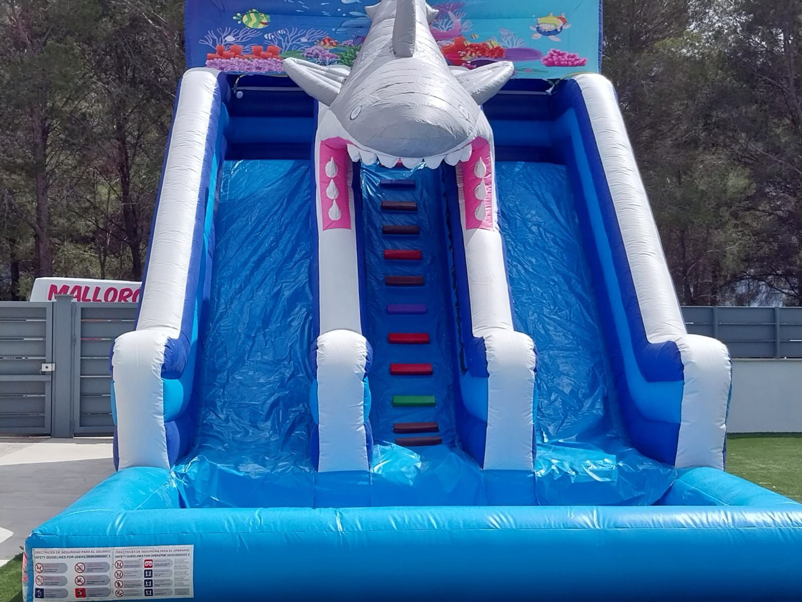 Un tobogán inflable con un tiburón encima.