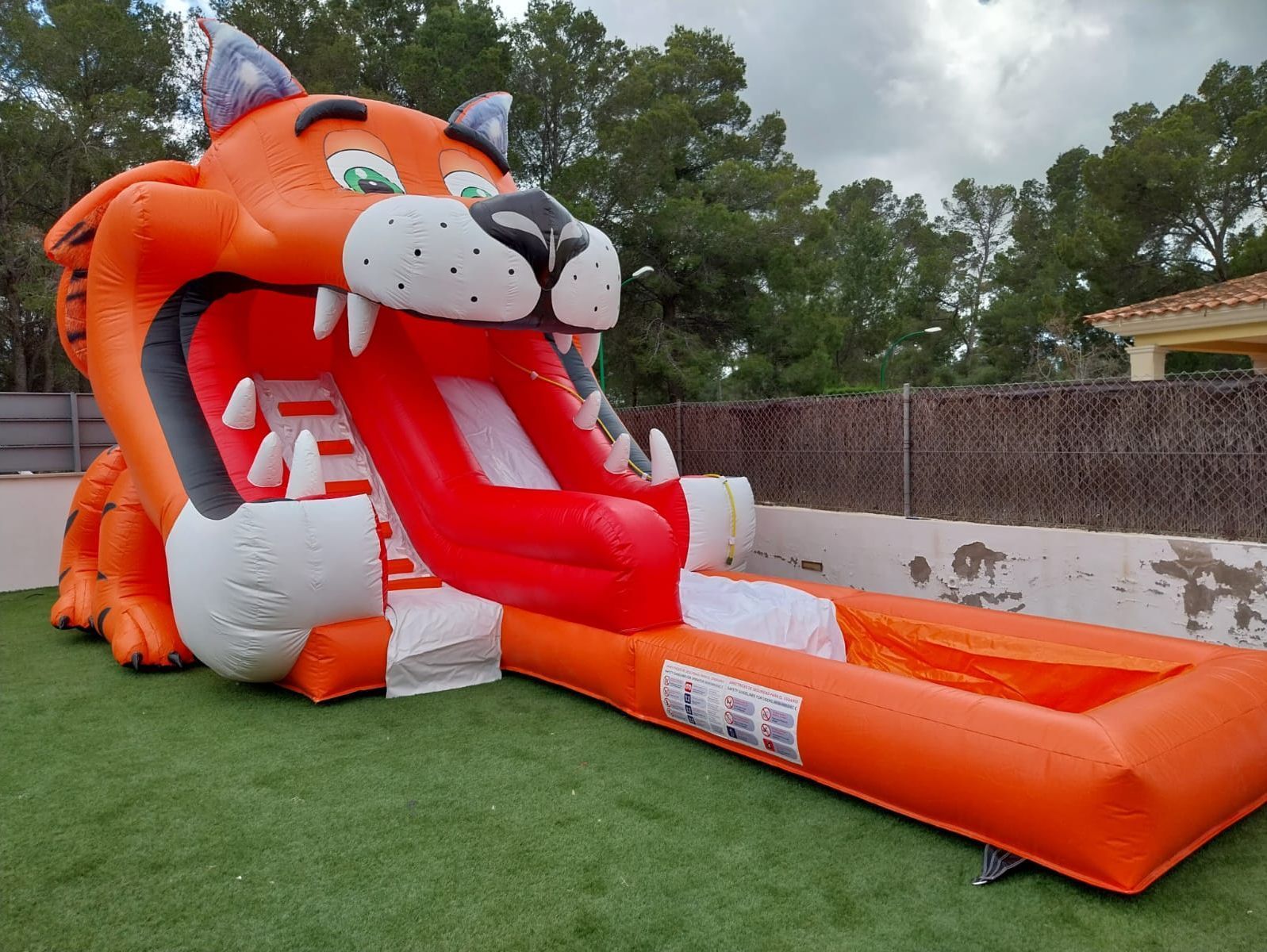 Un gran tigre inflable con un tobogán en la boca.
