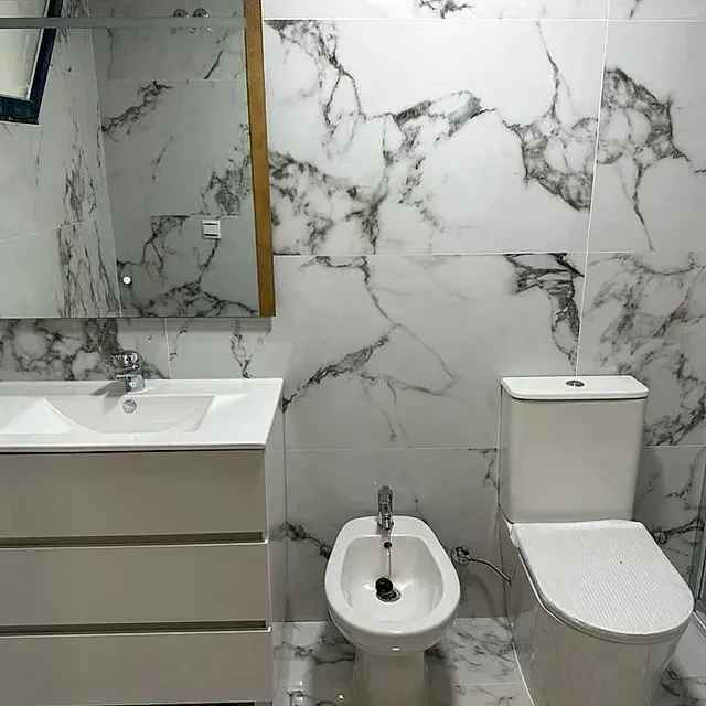 Un baño con lavabo, inodoro, bidé y espejo.