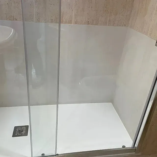Un baño con una puerta de ducha corrediza de cristal y un lavabo.