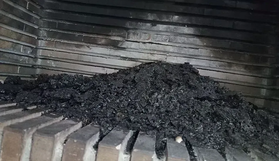 Una pila de carbón está encima de una chimenea de ladrillo.