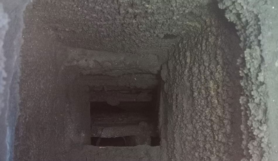 Un primer plano de una chimenea sucia con un agujero en ella.