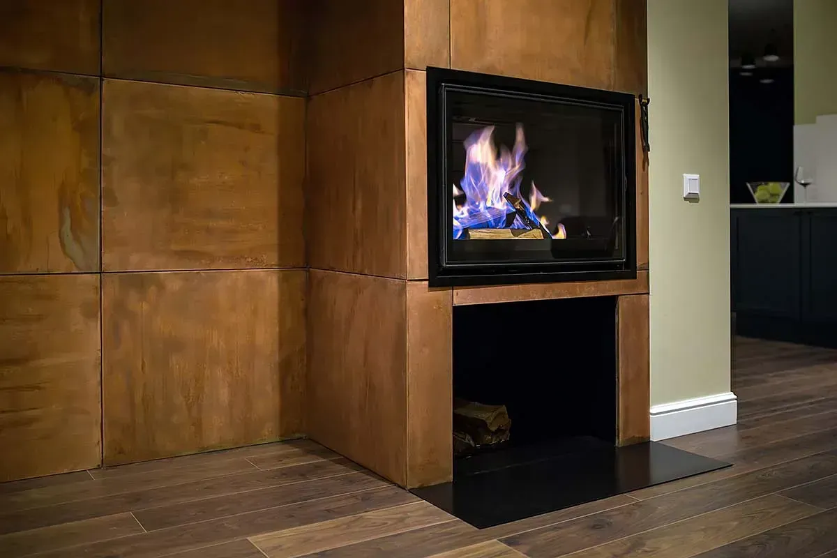 Una chimenea con una pared de madera y un suelo de madera en una sala de estar.